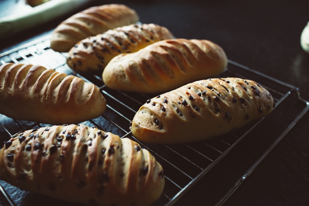 a bunch of loaves of bread sitting on a rack