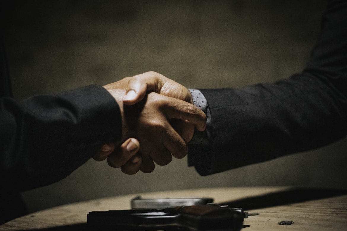 Two people shaking hands over a deal.