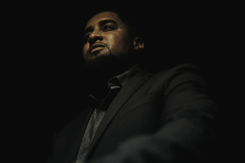 가을 도시 거리를 걷고 있는 비니와 재킷 차림의 남자 뒷모습