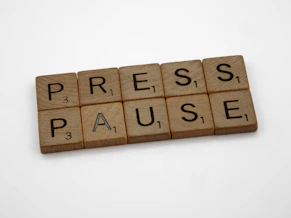 a scrabble of words spelling press pause