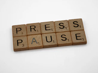 a scrabble of words spelling press pause