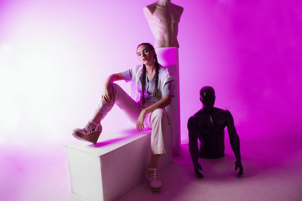 a woman sitting on a bench next to a mannequin