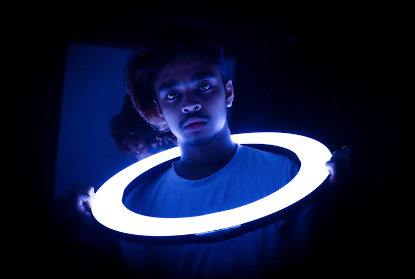 Close-up of the zeneio smart ring glowing with electric blue light against a dark void background.