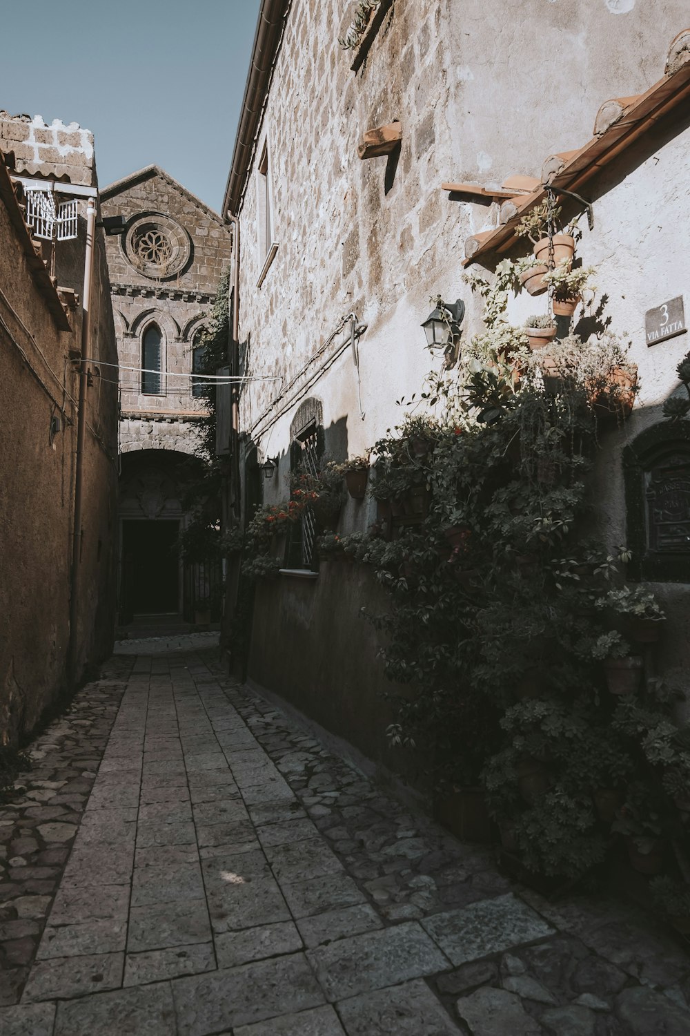 a narrow alley with a clock tower in the background