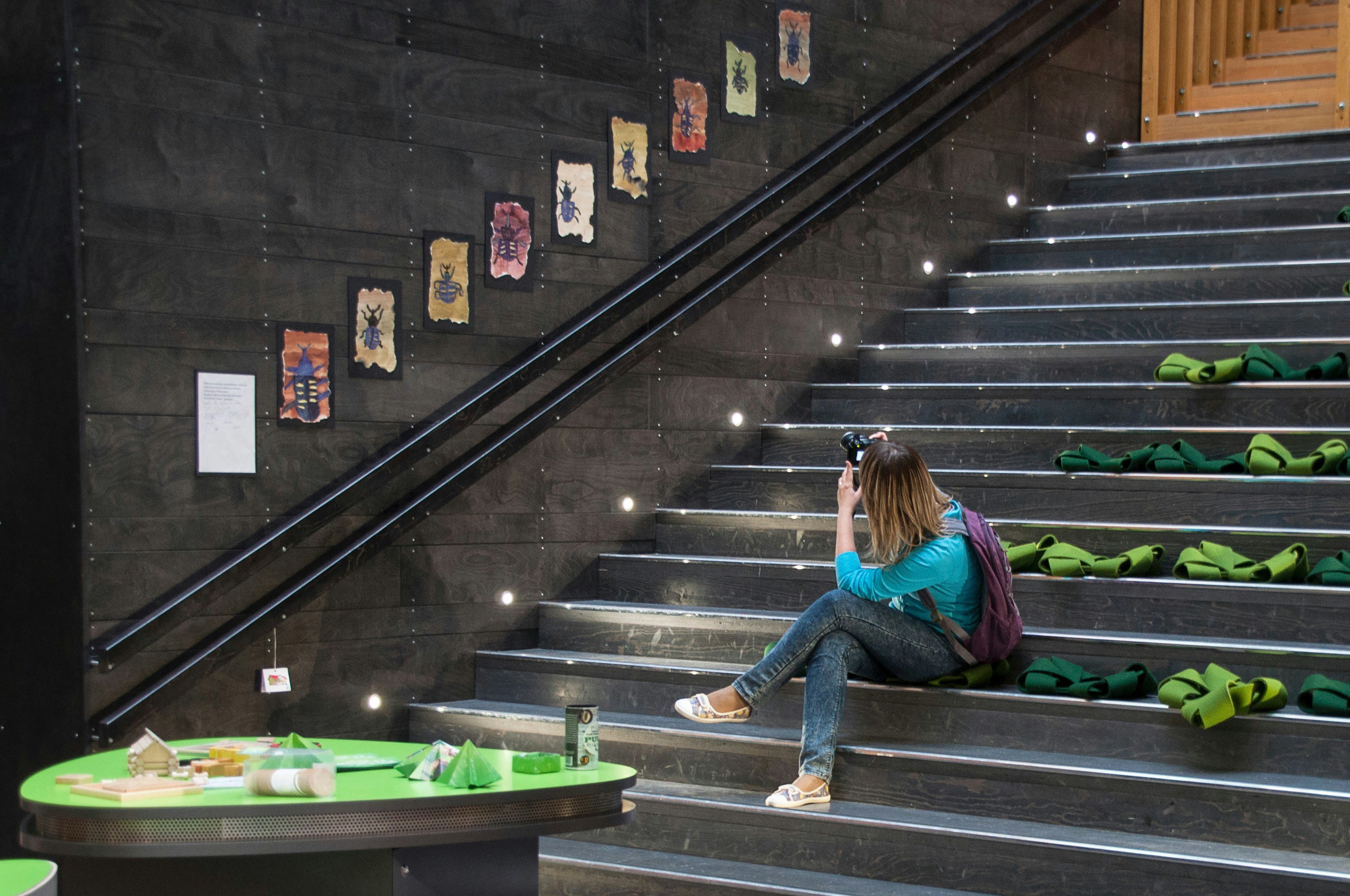 a woman sitting on a set of stairs taking a picture