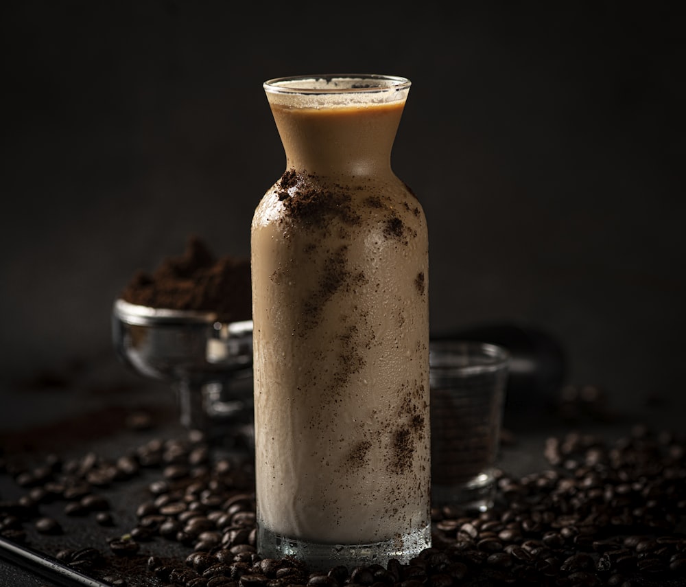 a bottle of coffee sitting on top of a pile of coffee beans