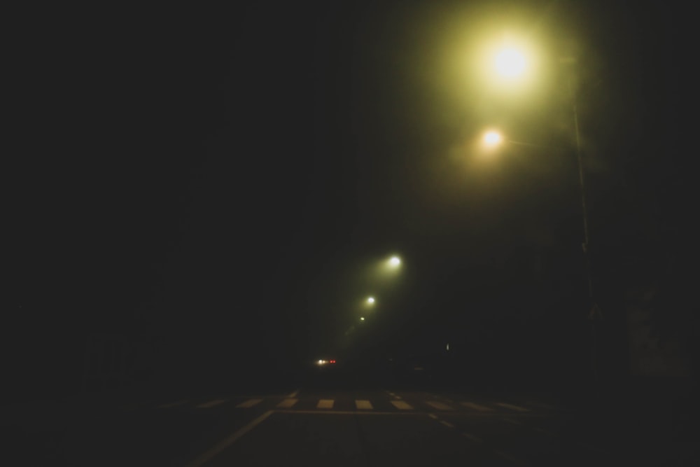 a street light shines brightly in the dark