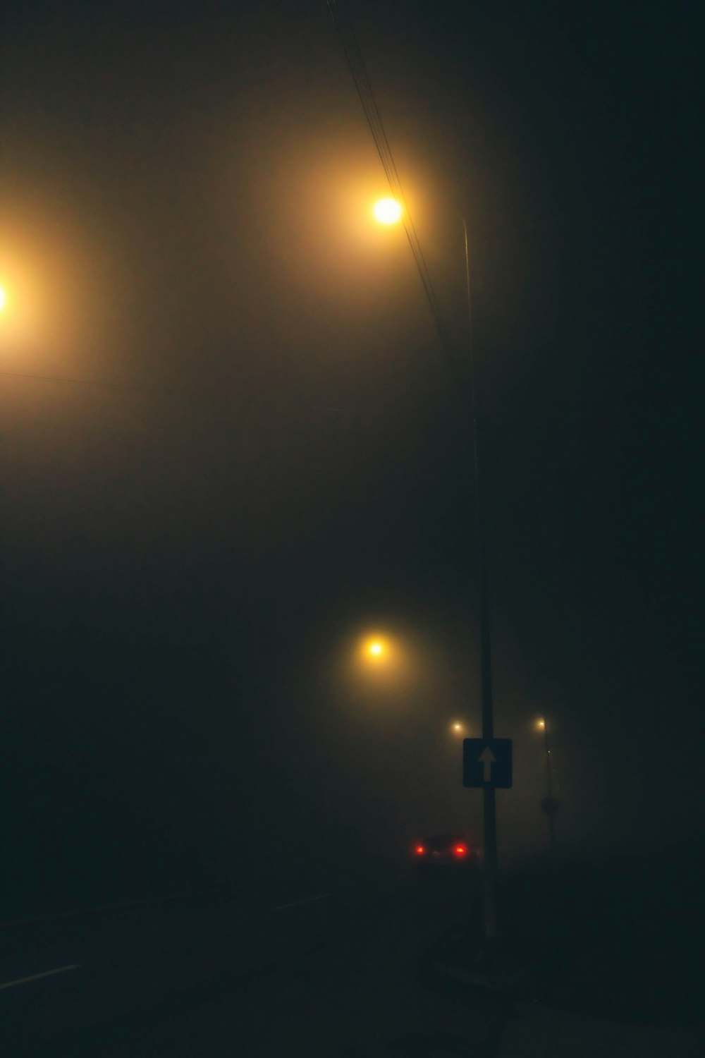 a foggy street at night with street lights