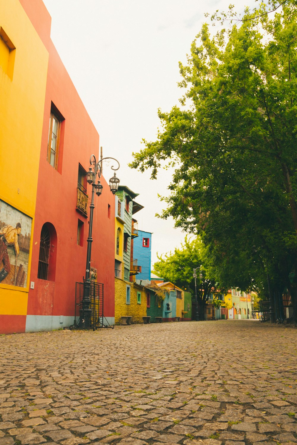 uma rua de paralelepípedos alinhada com edifícios de cores vivas