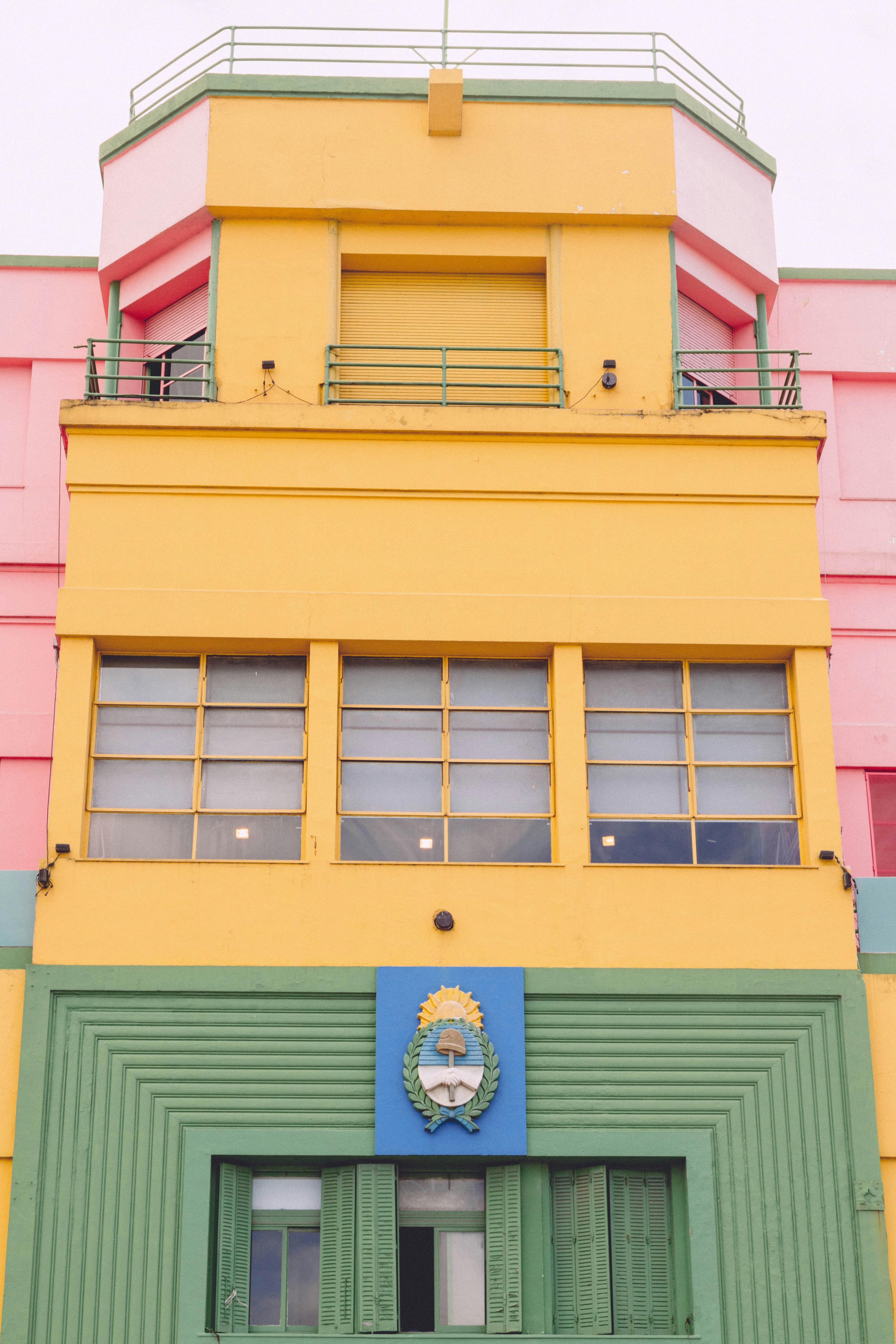 a yellow and green building with a clock on it
