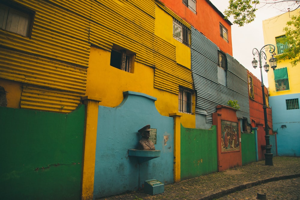 a row of multicolored buildings on a cobblestone street