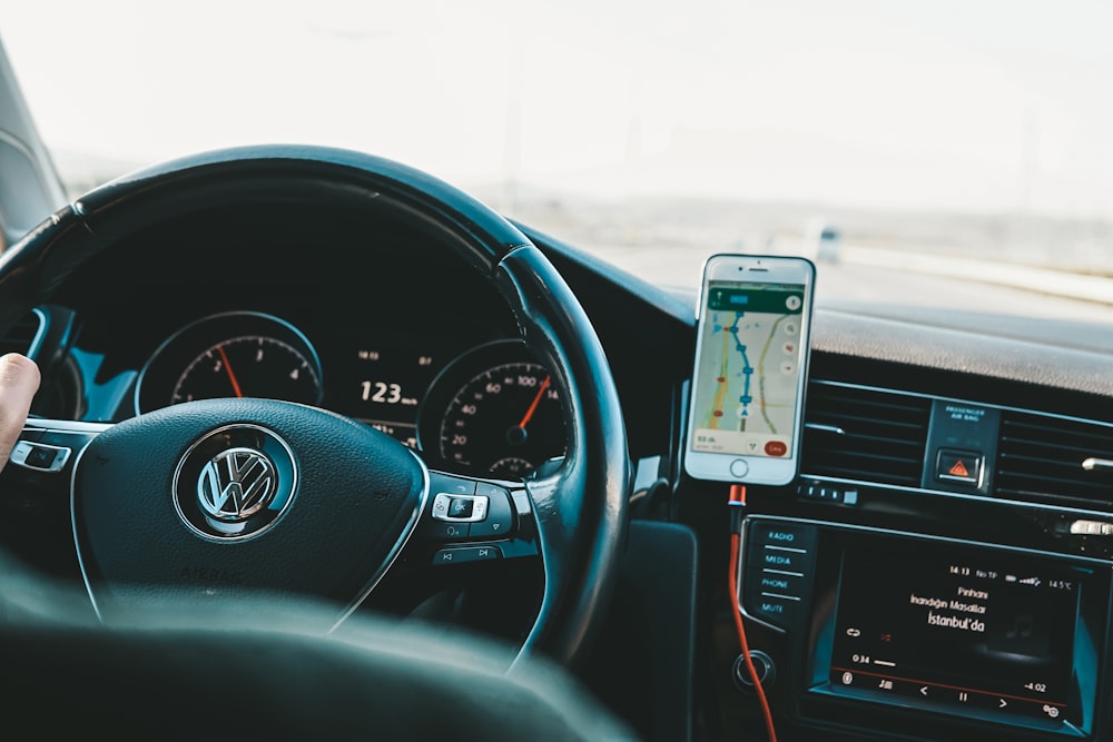 a person holding a cell phone while driving a car