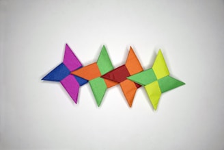 A collection of folded paper stars in various pastel colors arranged on a wooden table