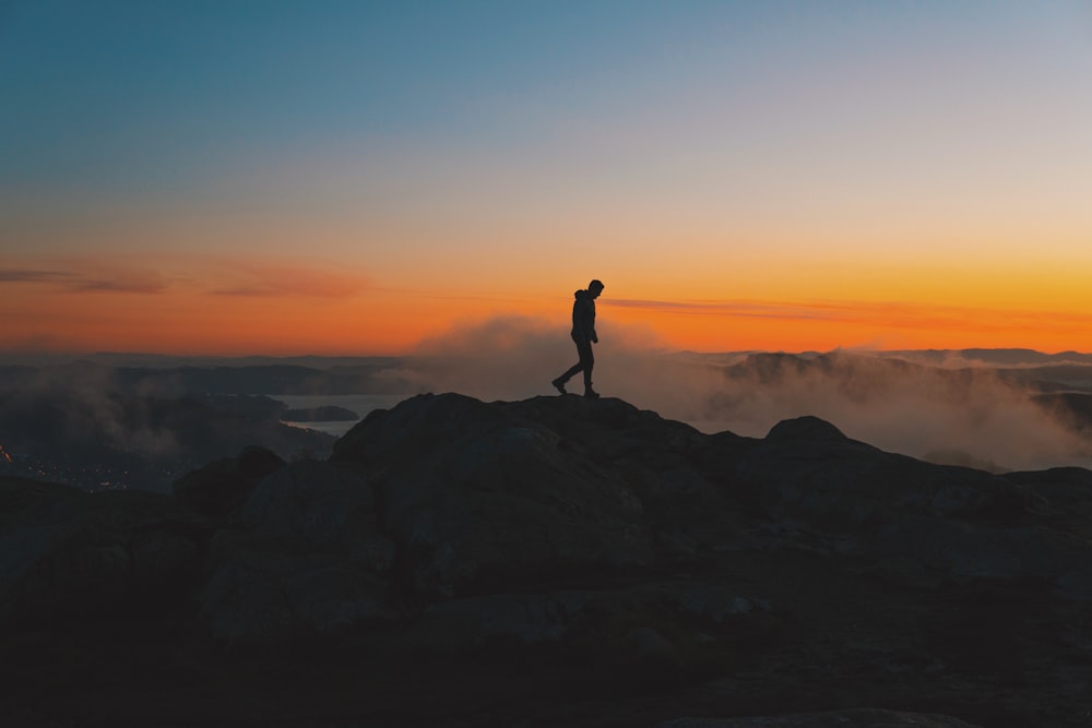 a person standing on top of a mountain at sunset