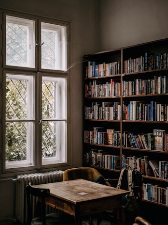A cozy classroom corner with art supplies and English books scattered on a wooden table.