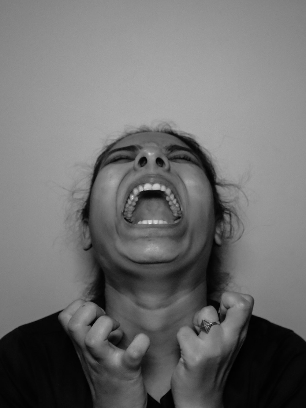 a woman with her mouth open and hands in front of her face