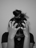 a woman covering her face with her hands in an emotional overwhelm