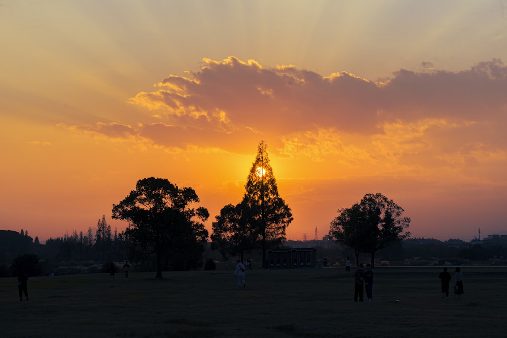 a group of people standing on top of a grass covered field