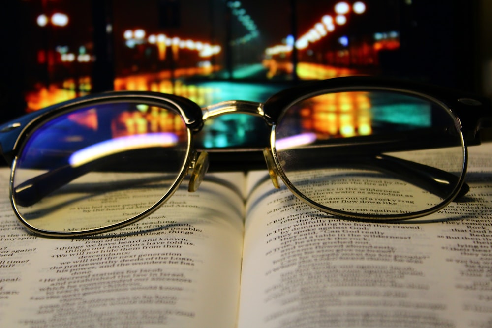 a pair of glasses sitting on top of an open book