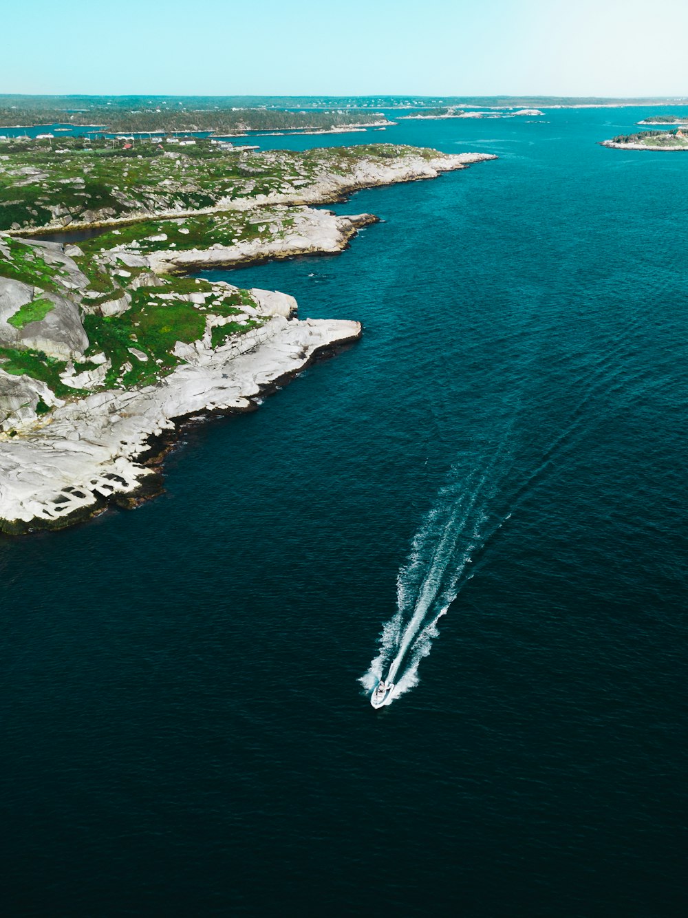 a boat is traveling through the water near the shore