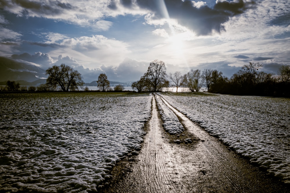 the sun shines through the clouds over a snowy field