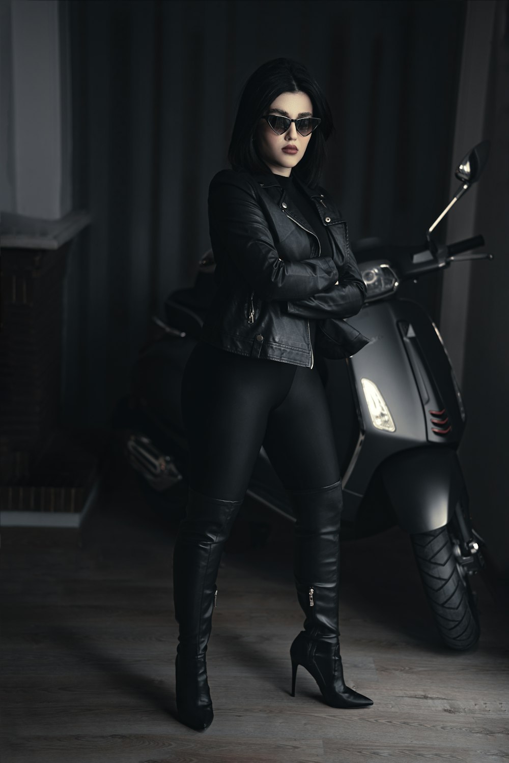 a woman in black is standing next to a motorcycle