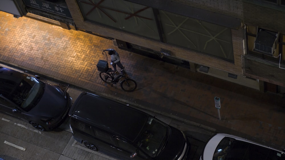 a man riding a bike down a street next to parked cars