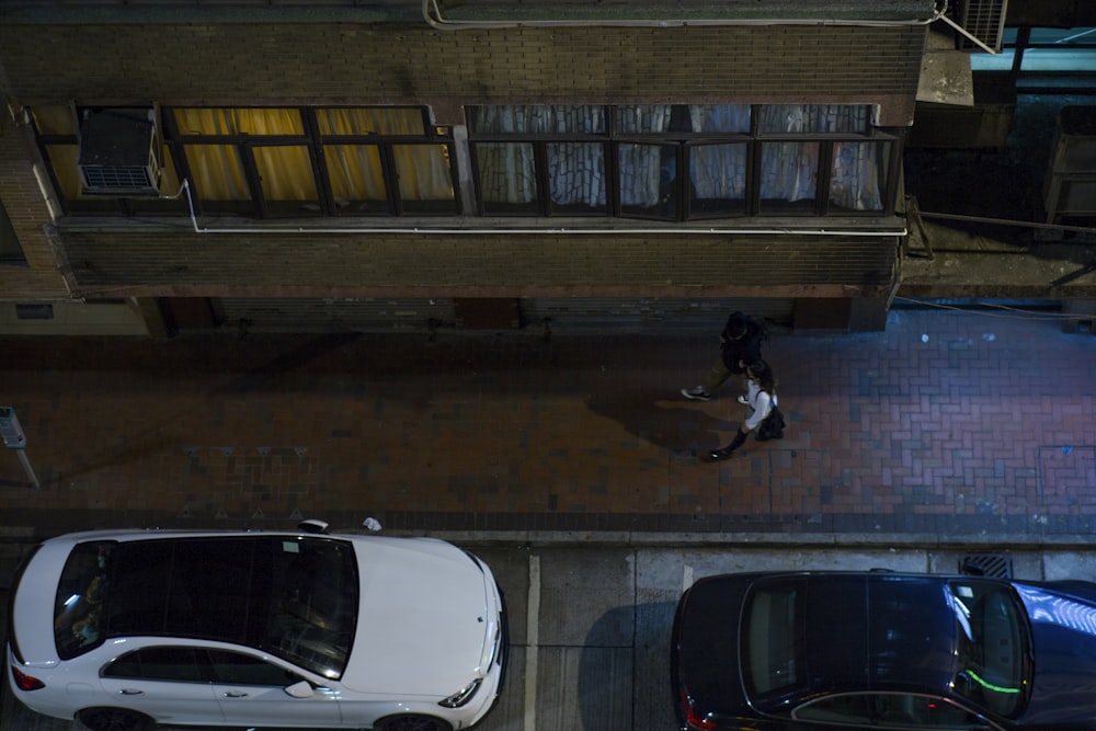 two cars parked next to each other in front of a building