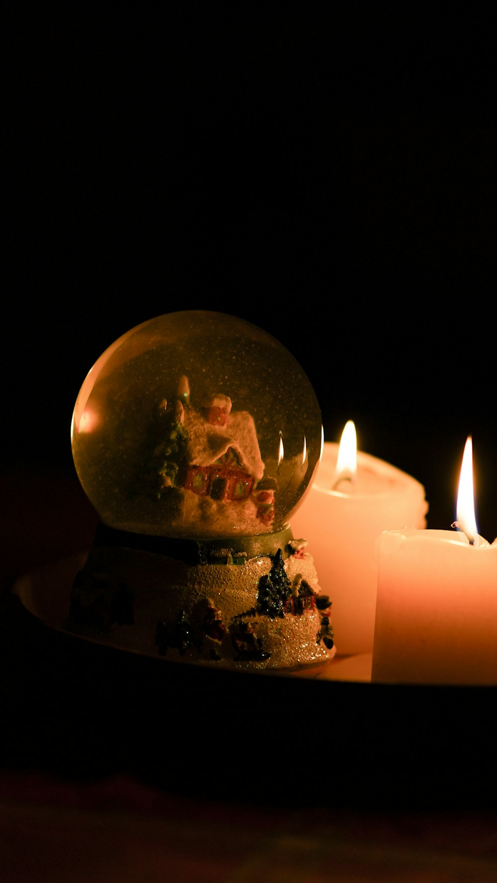 a snow globe sitting on top of a table next to candles