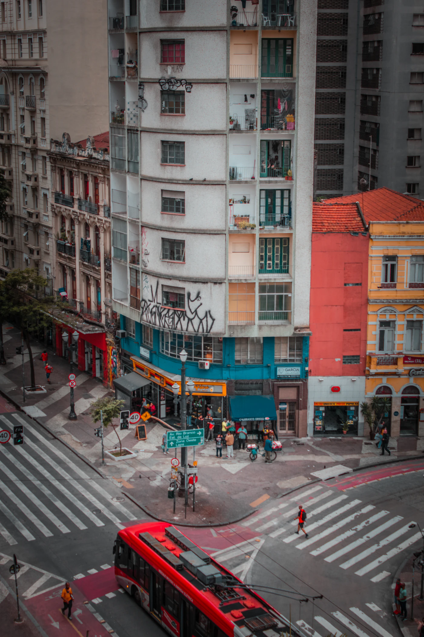 Red bus on an avenue lined with high-rises