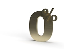 A large, three-dimensional golden 0% symbol positioned against a plain white background.