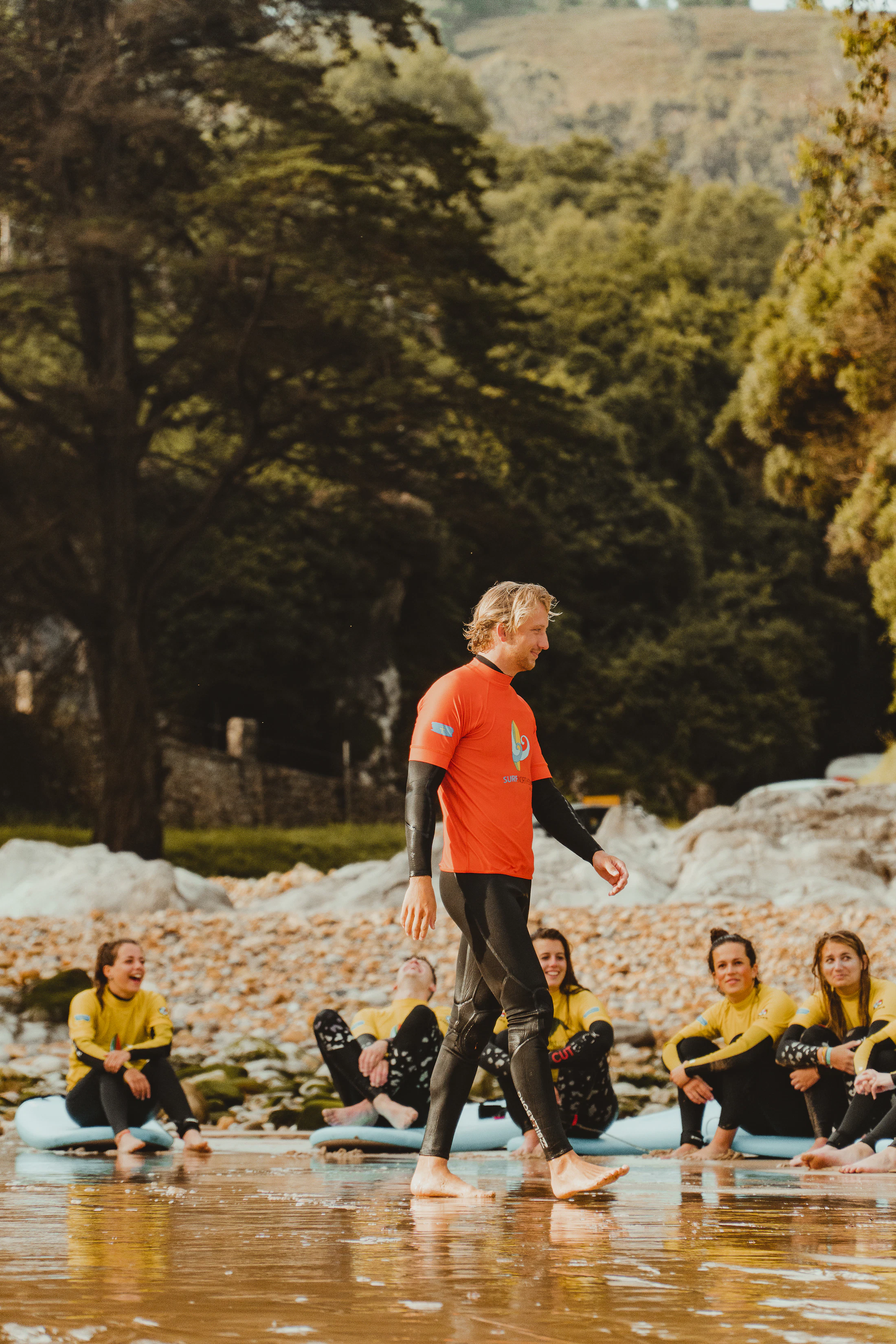 Surf instructor working with a group of people learning to surf