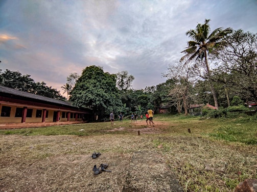 A group of people playing gateball on a sunny outdoor field.