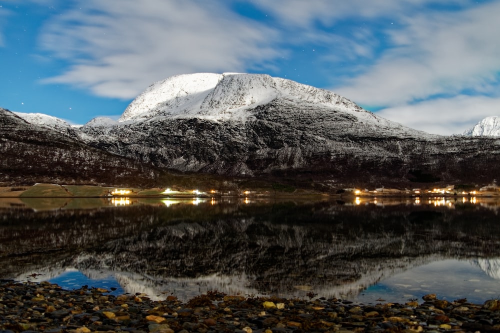 a snow covered mountain with a lake in front of it