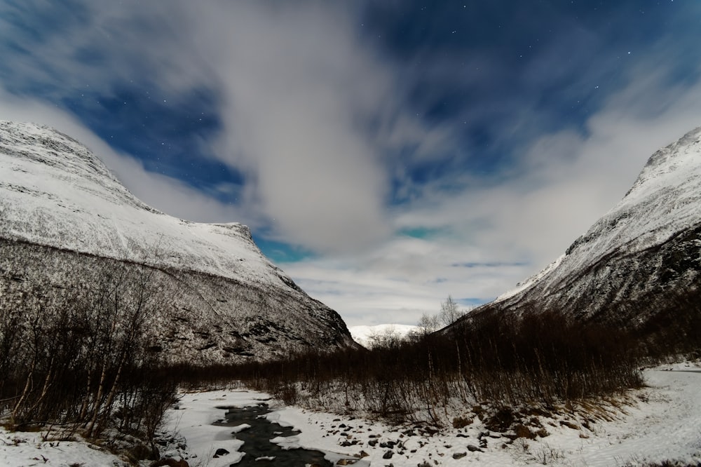 a snow covered mountain with a stream running through it