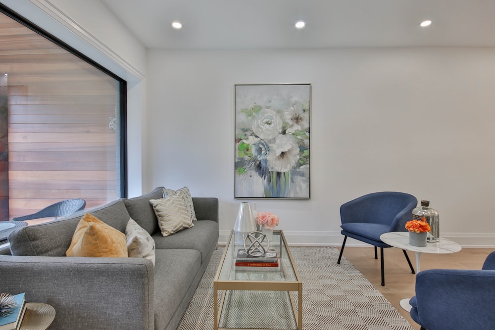 a living room filled with furniture and a painting on the wall