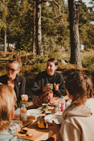 A group of smiling friends sharing stories around a picnic blanket in a sunlit park