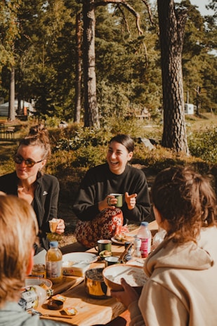 A group of friends laughing and playing games at a picnic.