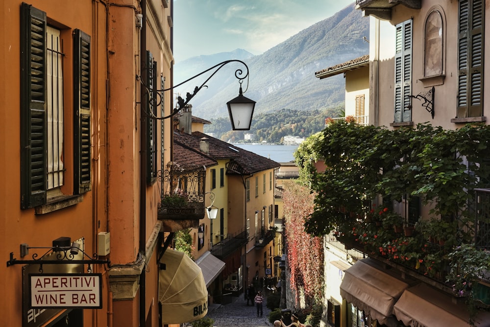 a narrow street in a small town with a mountain in the background