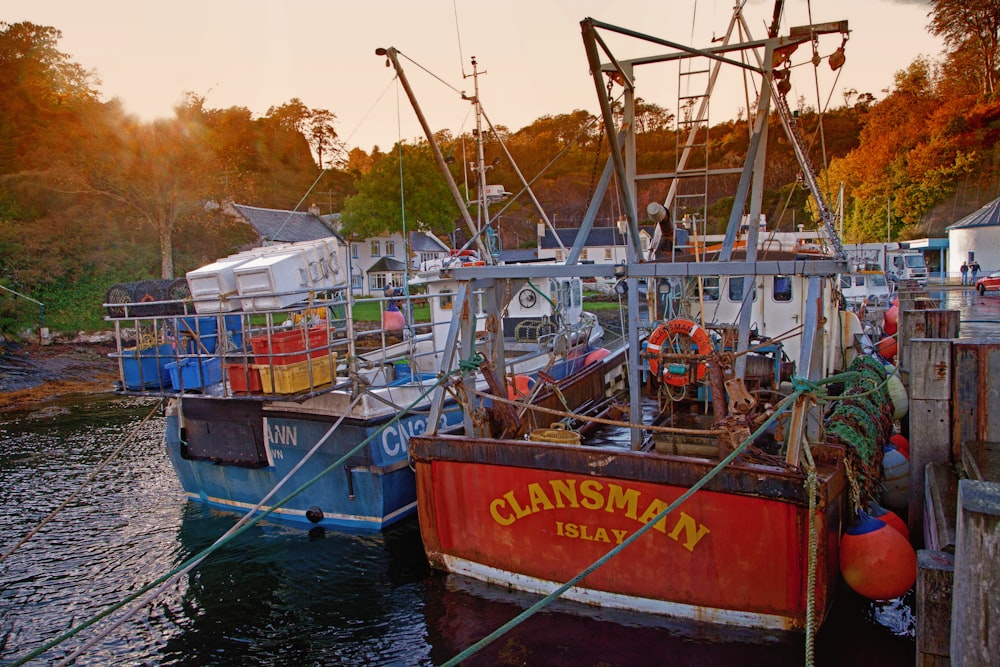 a red and blue fishing boat docked at a dock