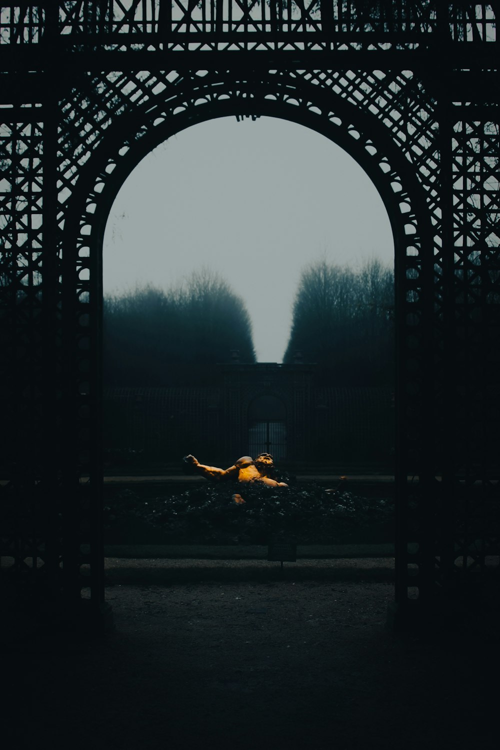 a person laying on a bench under an arch