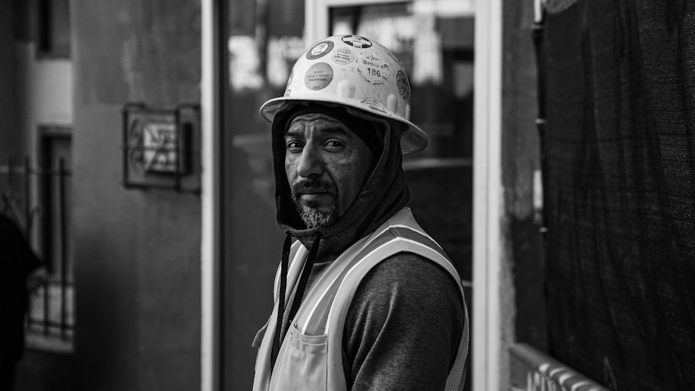 a man wearing a hard hat standing in front of a building