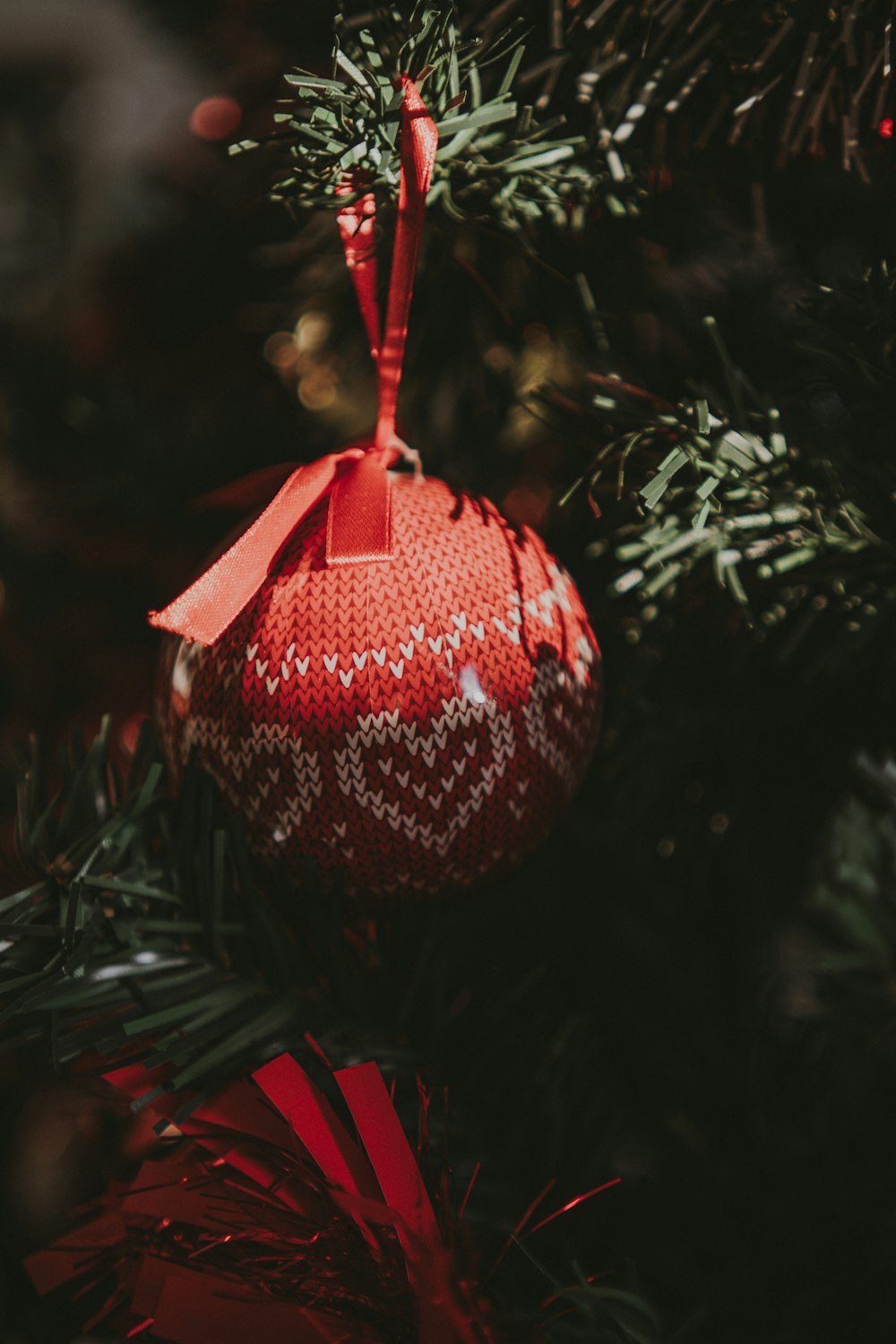 a red ornament hanging from a christmas tree