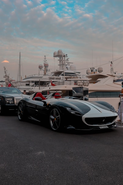 a black sports car parked in front of a boat