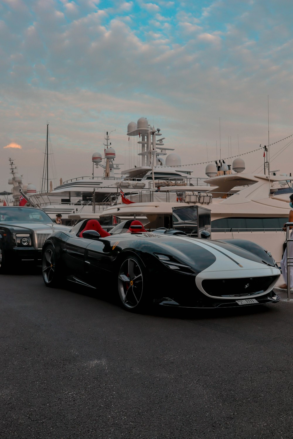 a black sports car parked in front of a boat