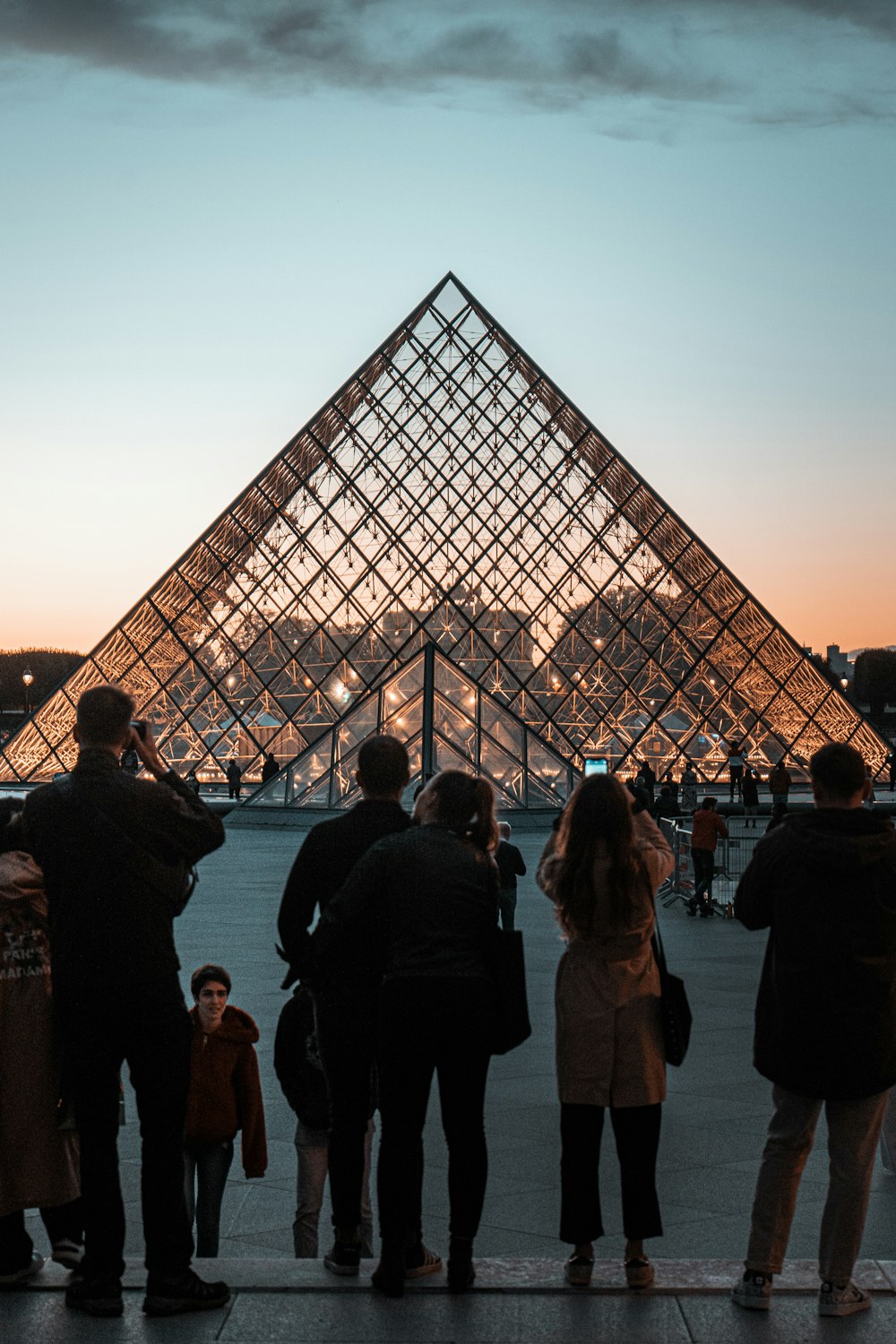 a group of people standing in front of a pyramid