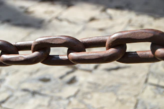 a close up of a metal chain on a stone surface
