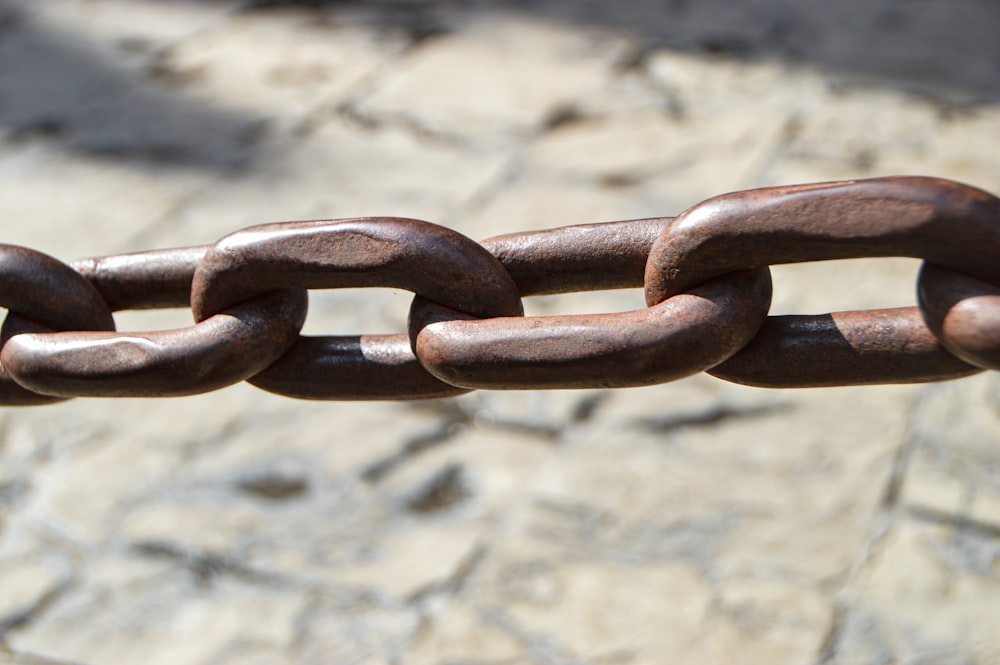 um close up de uma corrente de metal em uma superfície de pedra