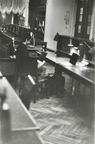 Black and white photo of university students studying together in a library.