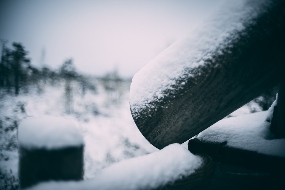 a close up of a bench covered in snow